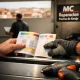 Manos de un propietario revisando un folleto de pago a plazos para la instalación de puertas de garaje en Madrid.