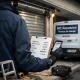 Técnico inspecciona puerta de garaje enrollable; Cual es el servicio mas economico para reparar puertas de garaje enrollables en Madrid