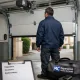 Técnico inspecciona una puerta de garaje abierta en Madrid; Cuales son los servicios mas populares para la reparacion de puertas de garaje en Madrid