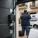 Puerta seccional antracita con motor y técnico verificando su alineación en una entrada de garaje de Barcelona; soluciones personalizadas.